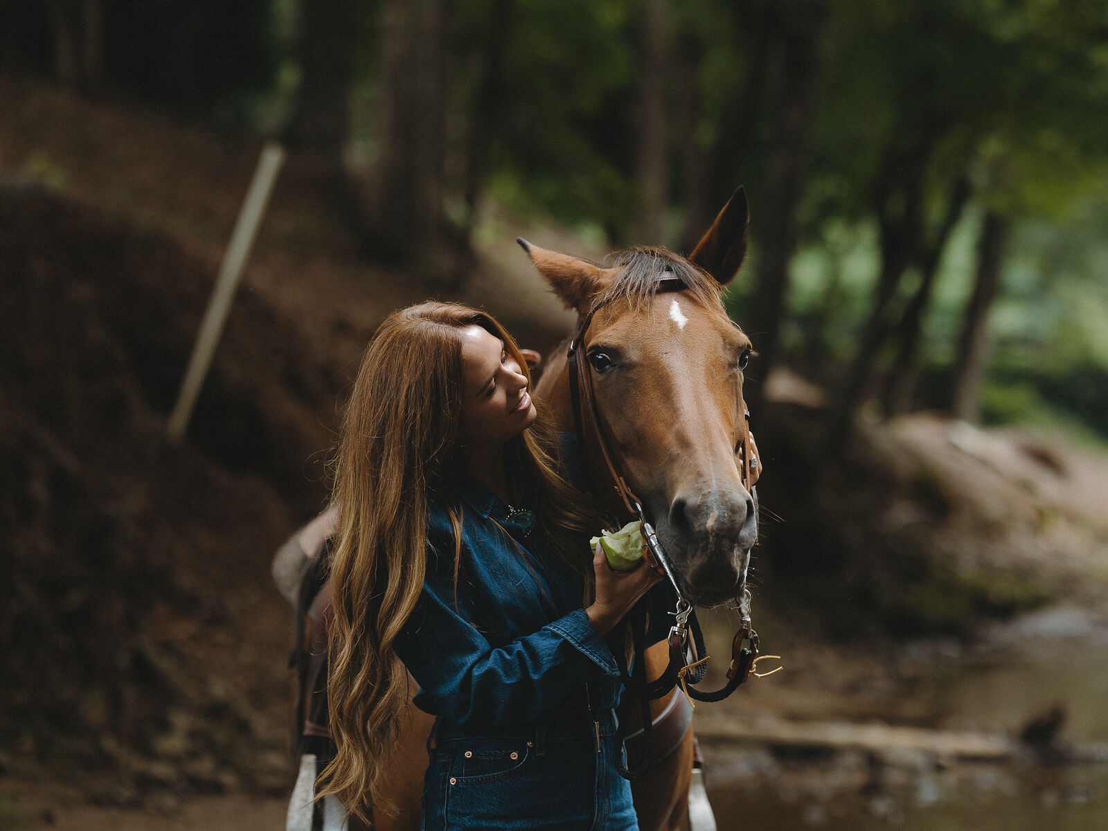 Woman leading a horse through a stream